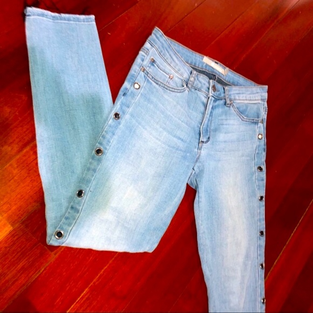 Light wash denim jeans frayed hem silver grommets